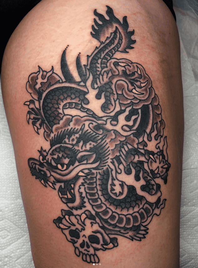 Black and white tattoo of a dragon.