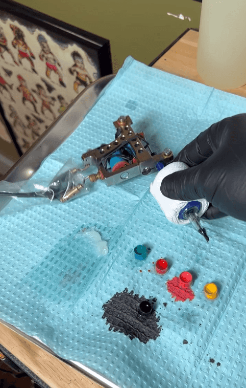 Artist tattooing a leg.