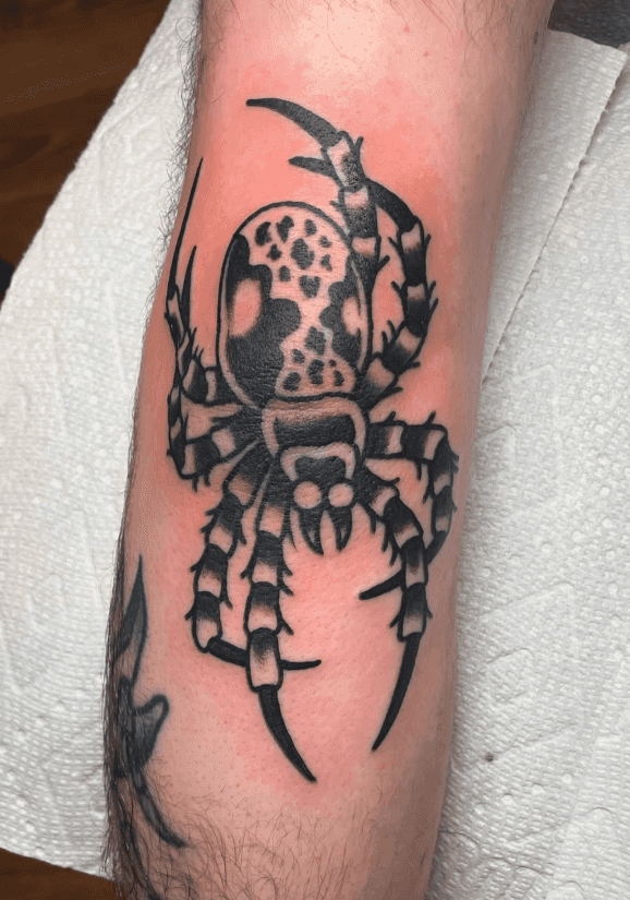 Black and white tattoo of a spider.